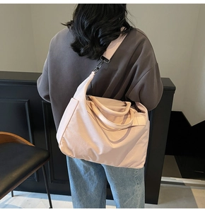 Detailansicht einer hellrosa Nylon-Tragetasche mit verstellbarem Schultergurt von hinten