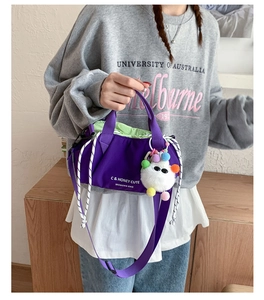 Purple nylon drawstring crossbody bag with neon green lining and cute monster charm