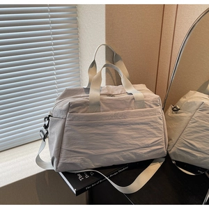 Détails du sac fourre-tout en nylon gris avec poignées renforcées et bandoulière réglable