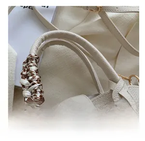Détail du sac à main blanc en cuir grainé avec fermoir doré et foulard pied-de-poule