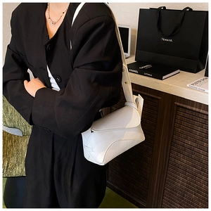 Detail of white lychee leather saddle bag with magnetic flap and thick shoulder strap