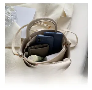 Intérieur spacieux du sac seau beige montrant le rangement d'objets essentiels