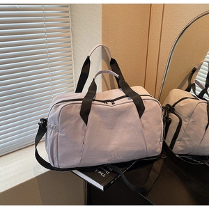 Macro shot of light purple travel bag showing separate bottom shoe compartment and handles
