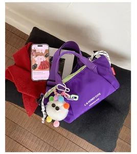 Purple nylon crossbody bag with cute monster charm on a stylish lifestyle background