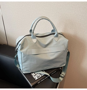 Detail der hellminzgrünen Nylontasche mit verstellbarem Gurt und Marken-Tragegriff