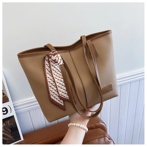 Brown lychee leather tote bag with elegant silk scarf detail and minimalist logo tag