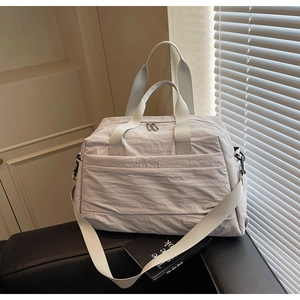 Détail du grand sac de voyage gris clair avec texture en nylon et bandoulière réglable