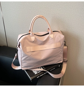 Detail der rosa Nylon-Tragetasche mit matter Textur und verstellbarem Ledergurt
