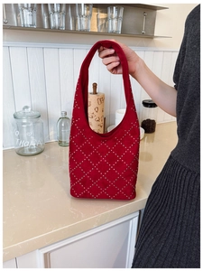 Dettaglio borsa a secchiello in camoscio rosso con borchie argento a rombi vintage