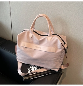 Detail der pinkfarbenen Nylontasche mit dicken Griffen und abnehmbarem Schultergurt
