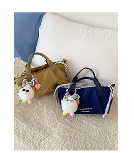 Detail of canvas bucket bags with drawstring closure and cute plush monster charms
