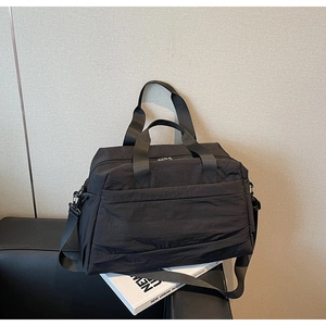 Détail d'un grand sac fourre-tout noir avec poignées renforcées et texture en toile