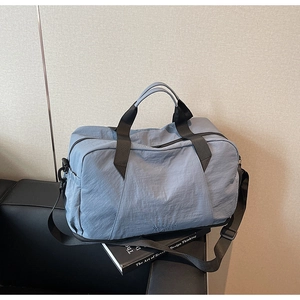 Detail of grey-blue fitness bag featuring reinforced handles and adjustable shoulder strap