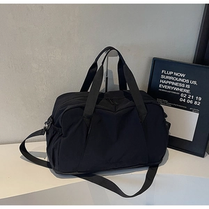Detail of black fitness bag featuring heavy-duty metal clips and adjustable shoulder strap