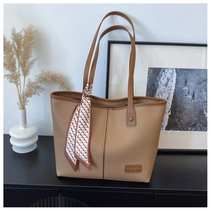 Detail of khaki tote bag with lychee texture, stitching, and decorative silk scarf