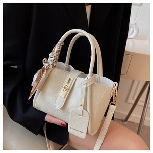 Détail du sac seau en cuir grainé blanc avec fermoir doré et foulard en soie