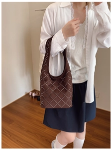 Borsa hobo in camoscio marrone con borchie argentate e motivo a rombi su modella