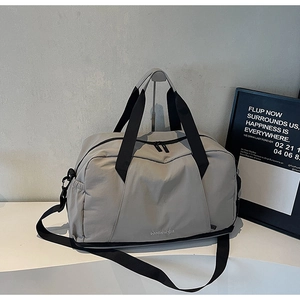 Close-up of a grey waterproof fitness bag with adjustable shoulder straps and top handles