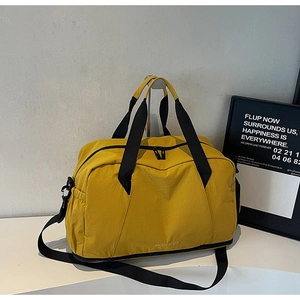 Close-up of yellow large gym bag with dual zippers and detachable black shoulder strap