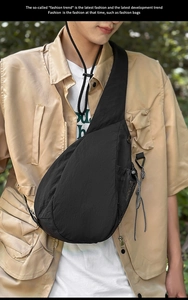 Detail view of a black teardrop chest bag with mesh side pockets and decorative zipper cord