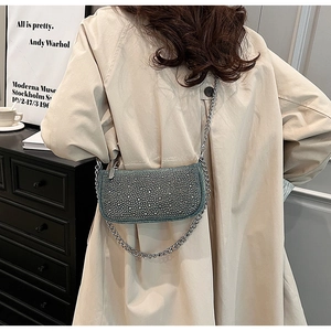Rear view of a model wearing the rhinestone denim baguette bag with silver chain strap