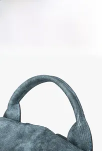 Detail of comfortable denim handle with solid stitching on stylish backpack