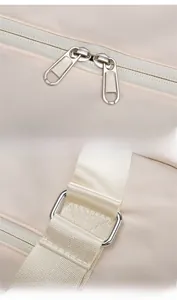 Detail of travel duffel with dual zippers and reinforced hardware on beige oxford fabric