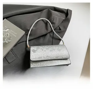 Detailed view of silver snakeskin texture on a luxury rectangular flap handbag