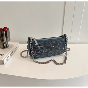 Detail of blue denim shoulder bag with sparkling silver rhinestones and chunky metal chain