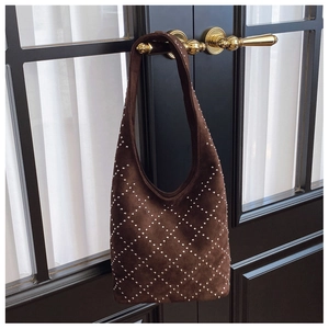 Dettaglio della borsa hobo retrò in pelle scamosciata marrone con borchie a rombi