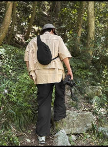 Outdoor view of a black nylon crescent chest bag worn across the back during hiking