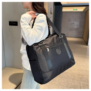 Close-up of black waterproof Oxford fabric gym bag with wide shoulder strap and side pocket