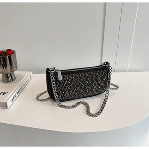 Close-up of black baguette bag with silver studs and thick chain strap detail