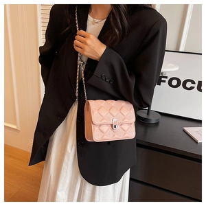 Dettaglio della borsa a tracolla rosa trapuntata indossata da modella in blazer nero