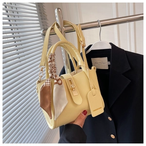 Détail du sac seau jaune texturé avec foulard en soie et fermoir rotatif en métal