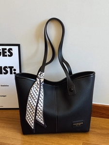 Minimalist black pebbled leather tote bag with stylish geometric scarf and long shoulder strap