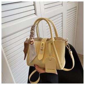 Détails du sac seau jaune en cuir grainé avec foulard en soie et boucle dorée élégante