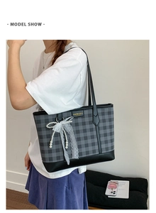 Detail of checkered tote bag featuring a lace pearl bow and metal brand plaque