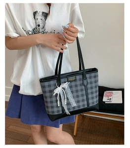 Close-up of checkered tote bag with delicate lace trim and pearl pendant detail