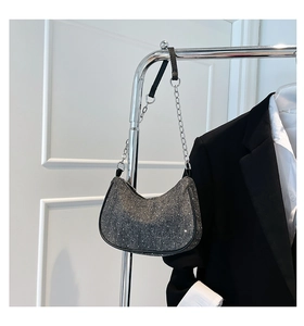 Detail view of a sparkling grey crescent bag with silver chain and leather strap
