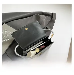 Internal view showing double compartments of black faux snake skin handbag with essentials