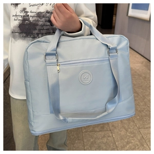 Detail view of light blue travel bag with waterproof fabric and reinforced handles