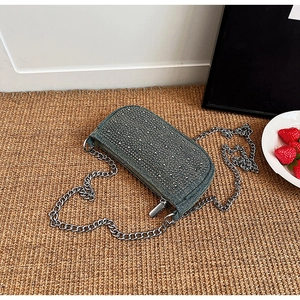 Detail view of denim crossbody bag with silver rhinestones and metal chain strap