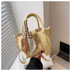 Détail du sac seau jaune citron avec texture litchi et foulard en soie décoratif