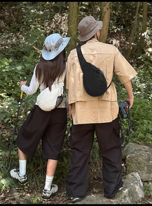 Outdoor hiking scene featuring two people wearing lightweight waterproof nylon crossbody bags