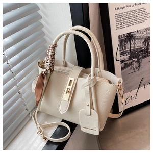 Détail du sac seau crème en cuir grainé avec foulard en soie et fermoir doré