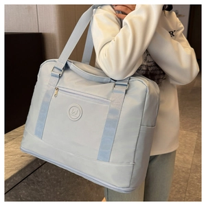 Close-up of light blue waterproof travel bag with front zipper and branded logo detail