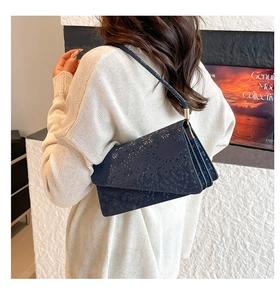 Detail of navy blue snakeskin texture shoulder bag with three-tier accordion structure