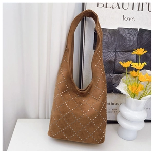 Dettaglio borsa hobo in pelle scamosciata marrone con borchie e trapuntatura