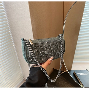 Detail of blue denim underarm bag with silver metallic studs and chunky chain strap
